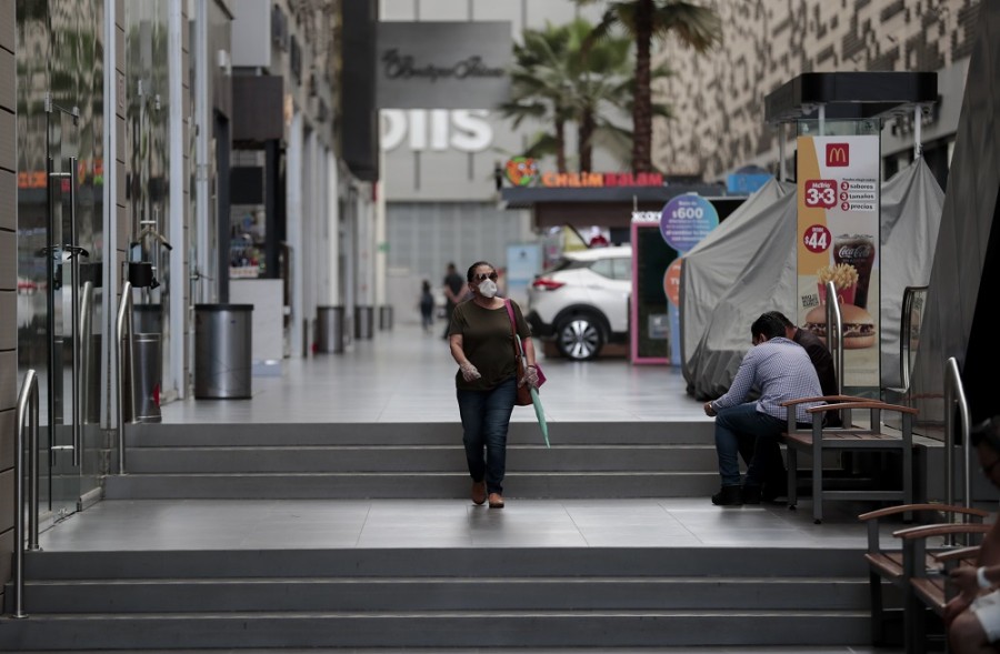 Una mujer con una máscara como medida de precaución contra la propagación del nuevo coronavirus camina dentro de un centro comercial cerrado en la Ciudad de México. El gobierno de México ha ampliado su cierre de actividades no esenciales como medida para evitar frenar el avance de la pandemia de covid-19. Foto AP/Eduardo Verdugo 