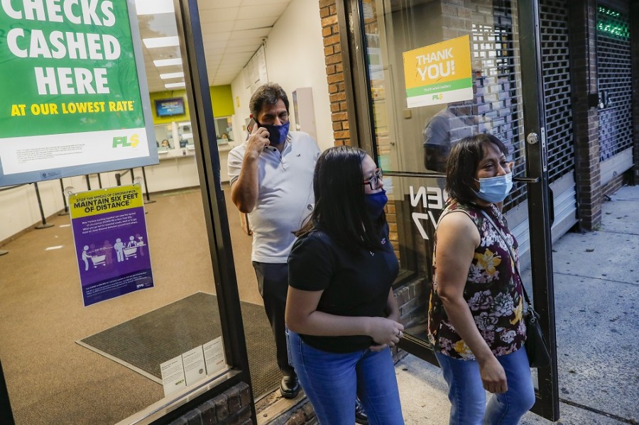 Un grupo de mexicanos en Estados Unidos sale de una sucursal de Western Union en Staten Island, Nueva York, tras enviar dinero a sus familiares en México. Foto AP/John Minchillo