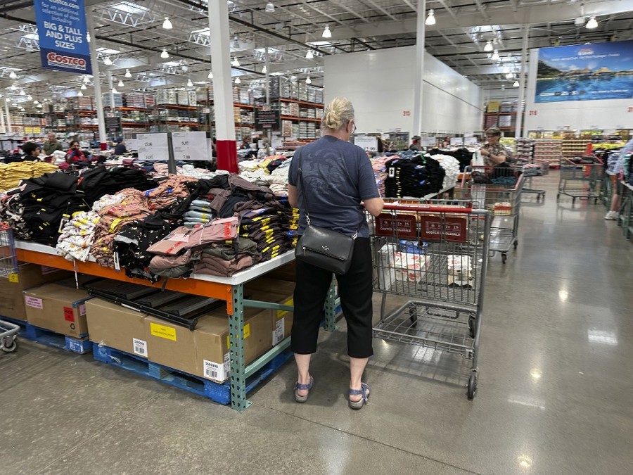 Un comprador revisa pilas de ropa en una mesa de ventas de un almacén de Costco el jueves 22 de junio de 2023, en Colorado Springs, Colorado. Foto AP/David Zalubowski