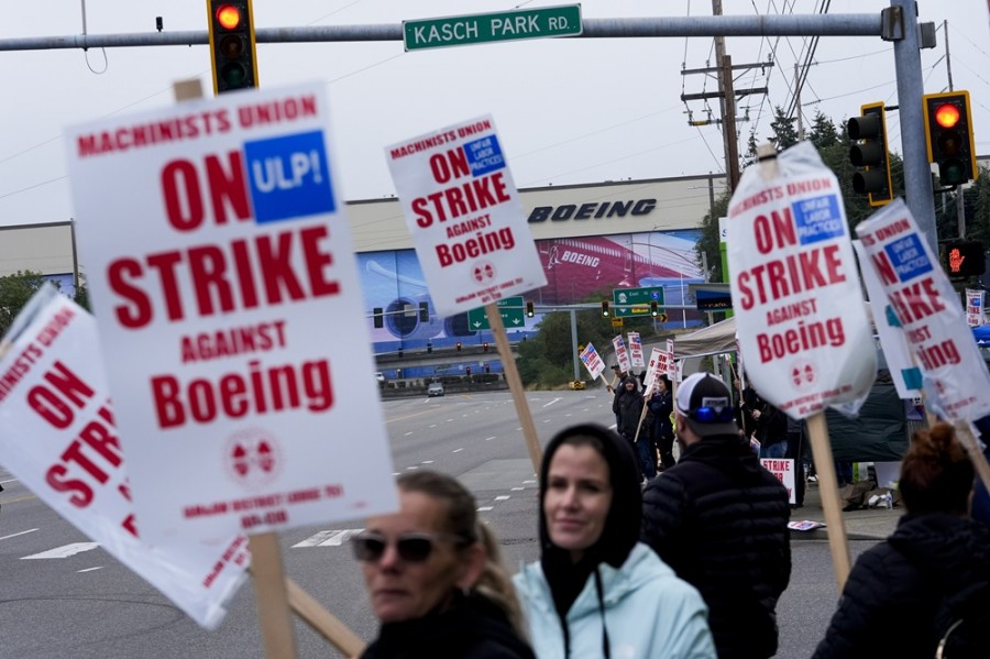 Los trabajadores de Boeing agitan carteles como parte de la huelga contra la compañía cerca de su fábrica en Everett, Washington. Foto AP/Lindsey Wasson