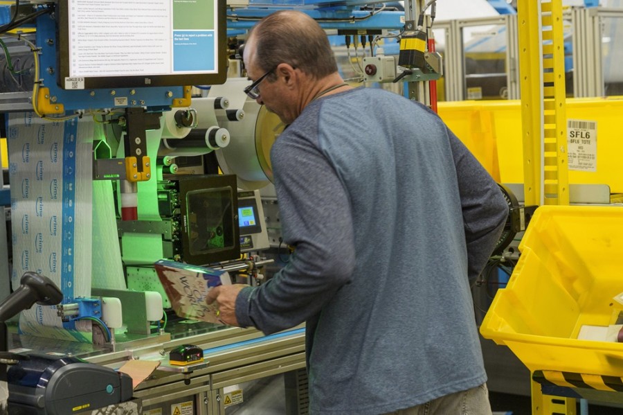 Un empleado utiliza una máquina de embalaje automatizada para crear una bolsa a medida para un libro en el centro logístico OXR1 de Amazon en Oxnard, California. Foto AP/Damian Dovarganes